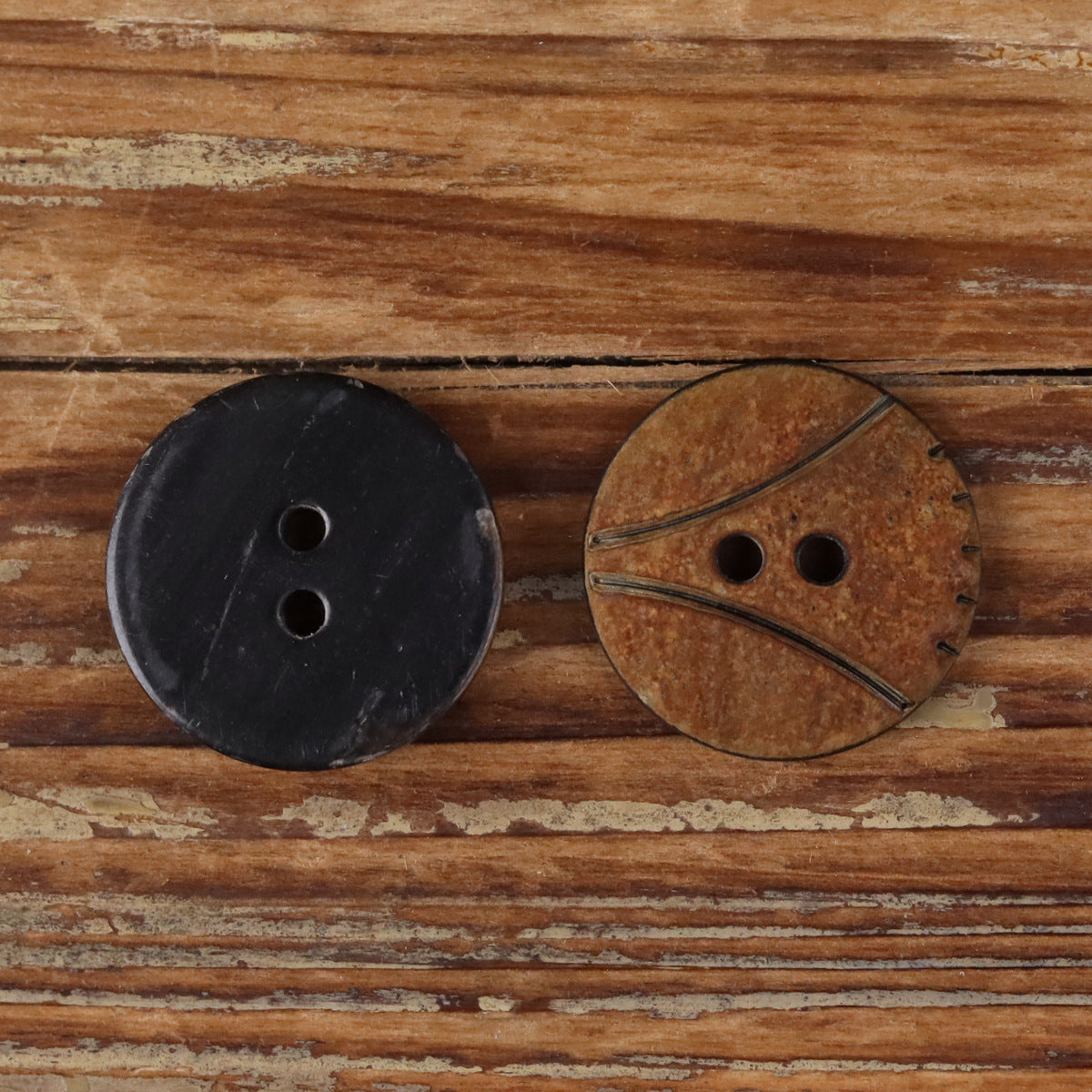 Round 2-hole horn buttons, one dark and one brown with scorched edge detail