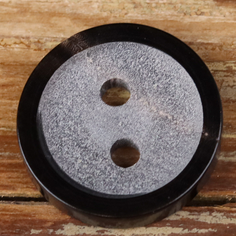 Round two-hole horn button with gray face and dark outer edge