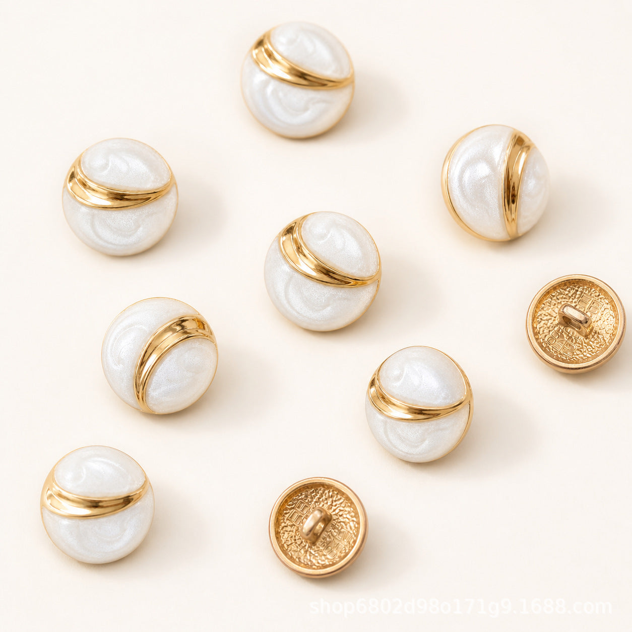 Multiple round buttons with white embossed faces and gold metal rims, mix of fronts and backs