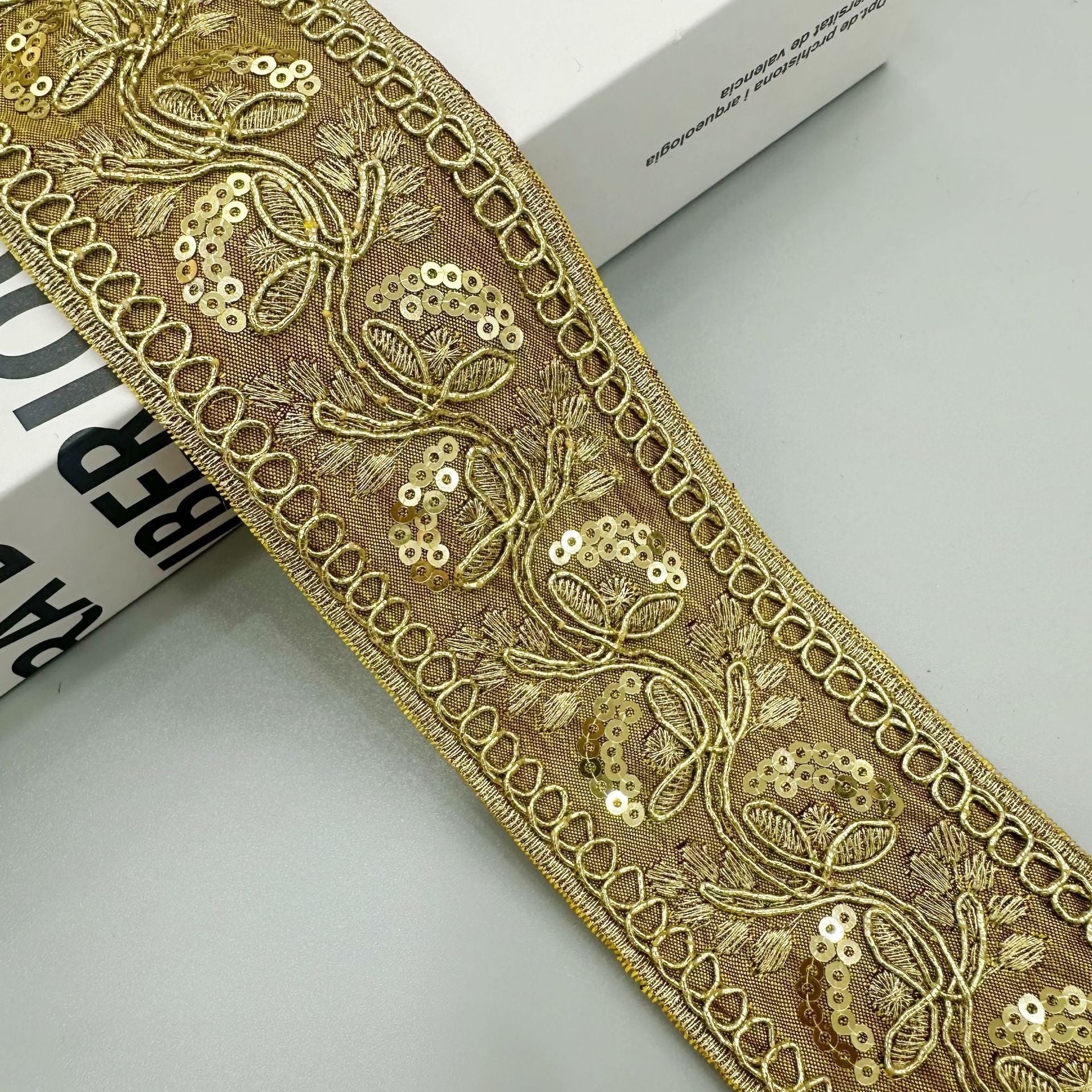 Gold sequin embroidered lace trim ribbon in gold/bronze with floral scroll motifs