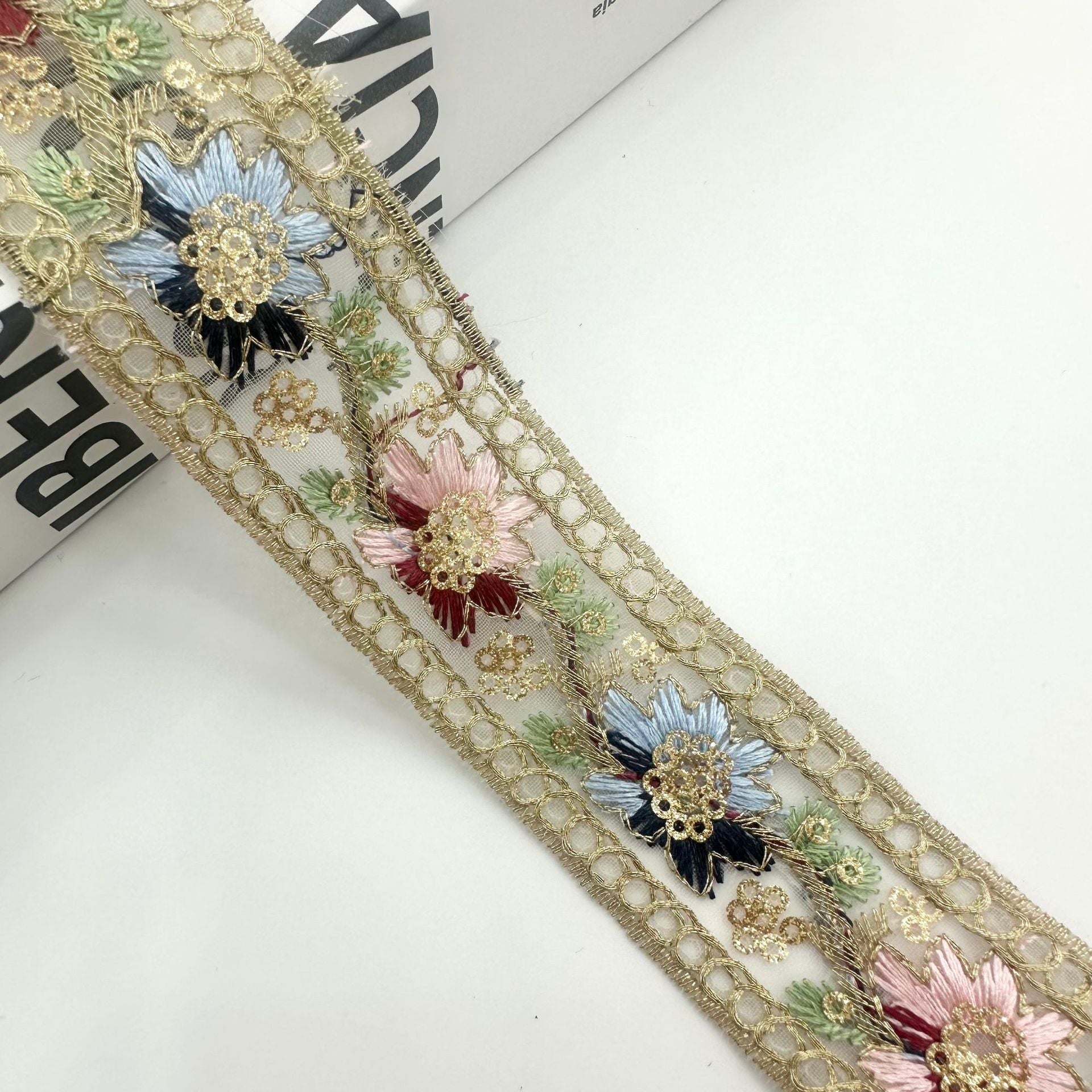 Gold-tone embroidered ribbon trim with blue and pink flower sequins and scalloped edge