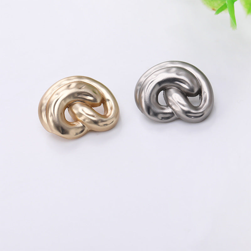 Gold and silver ear-shaped metal shank buttons, swirl cutout front
