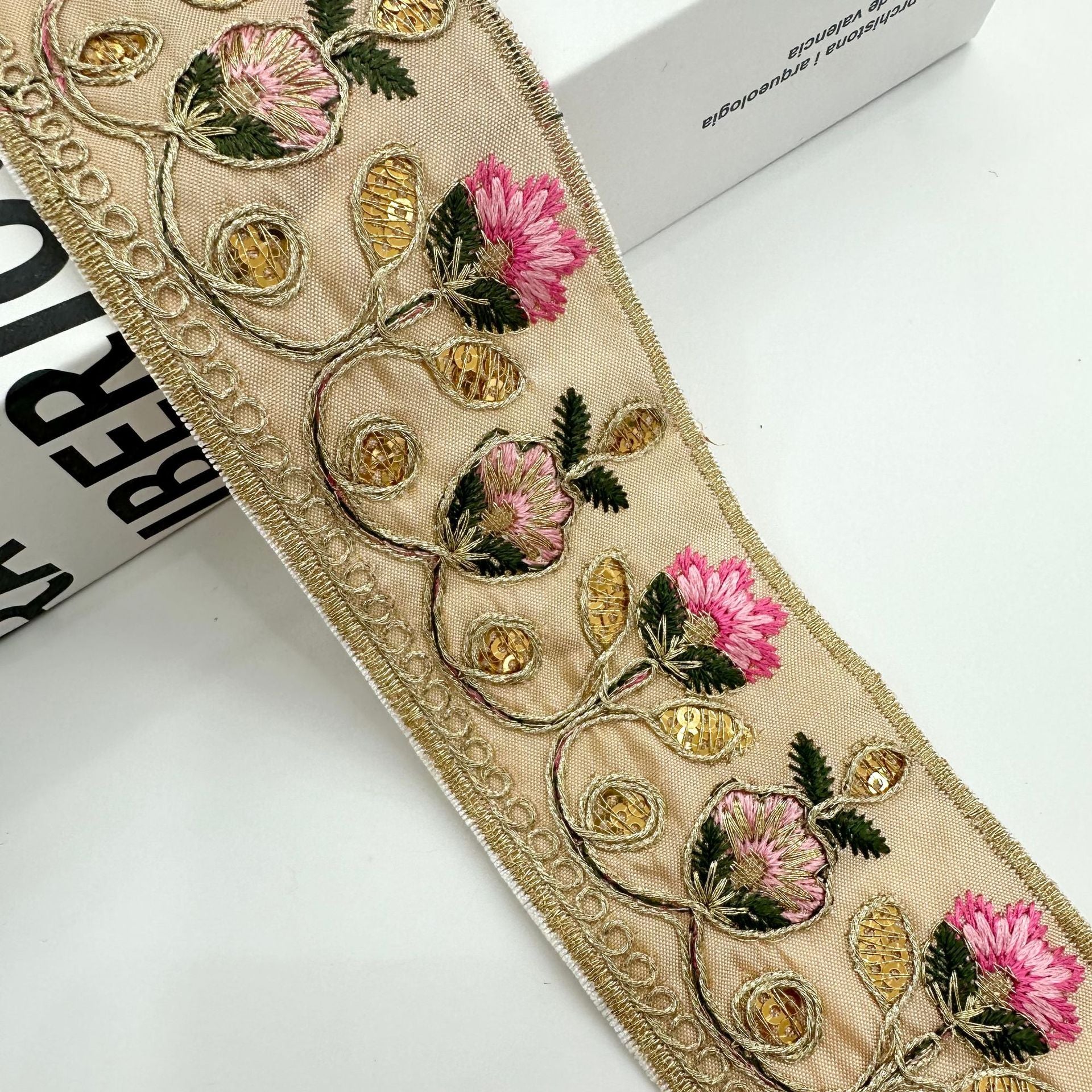 Beige embroidered lace trim ribbon with gold beads, pink flowers, and leafy accents
