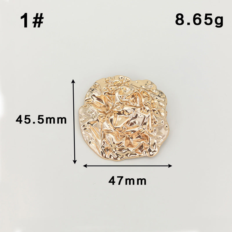 Gold abstract circular metal brooch with safety-pin clasp