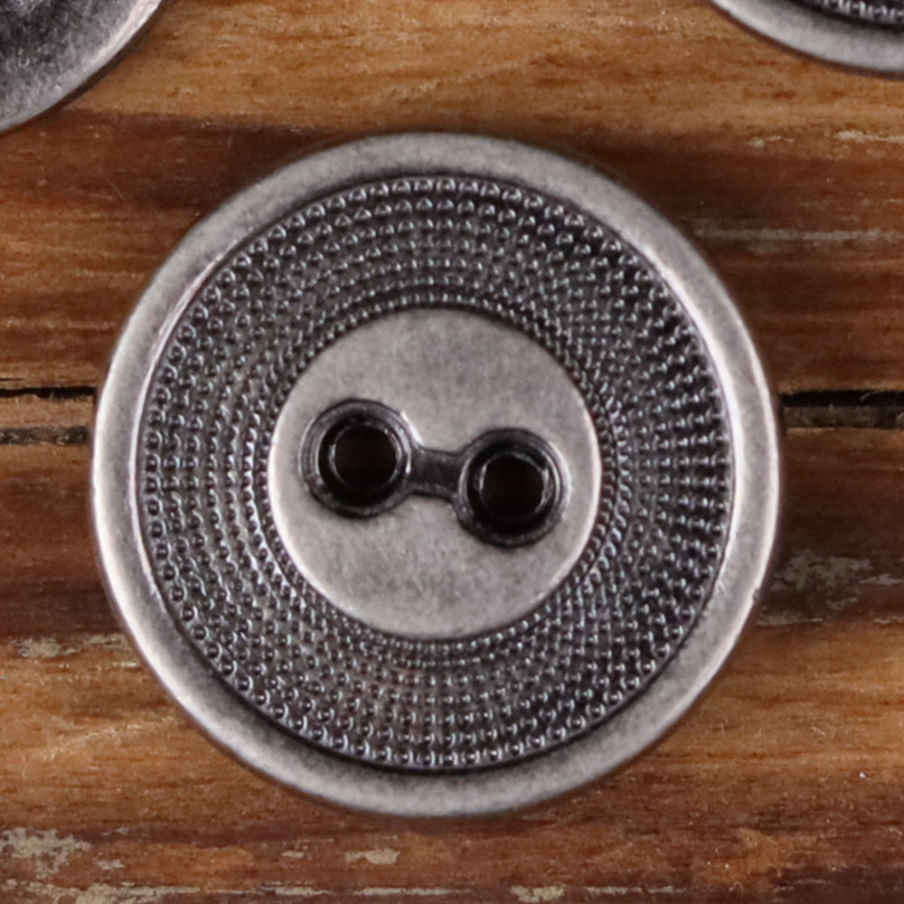 Close-up of a 2-hole metal button with concentric circle edge texture, silver finish