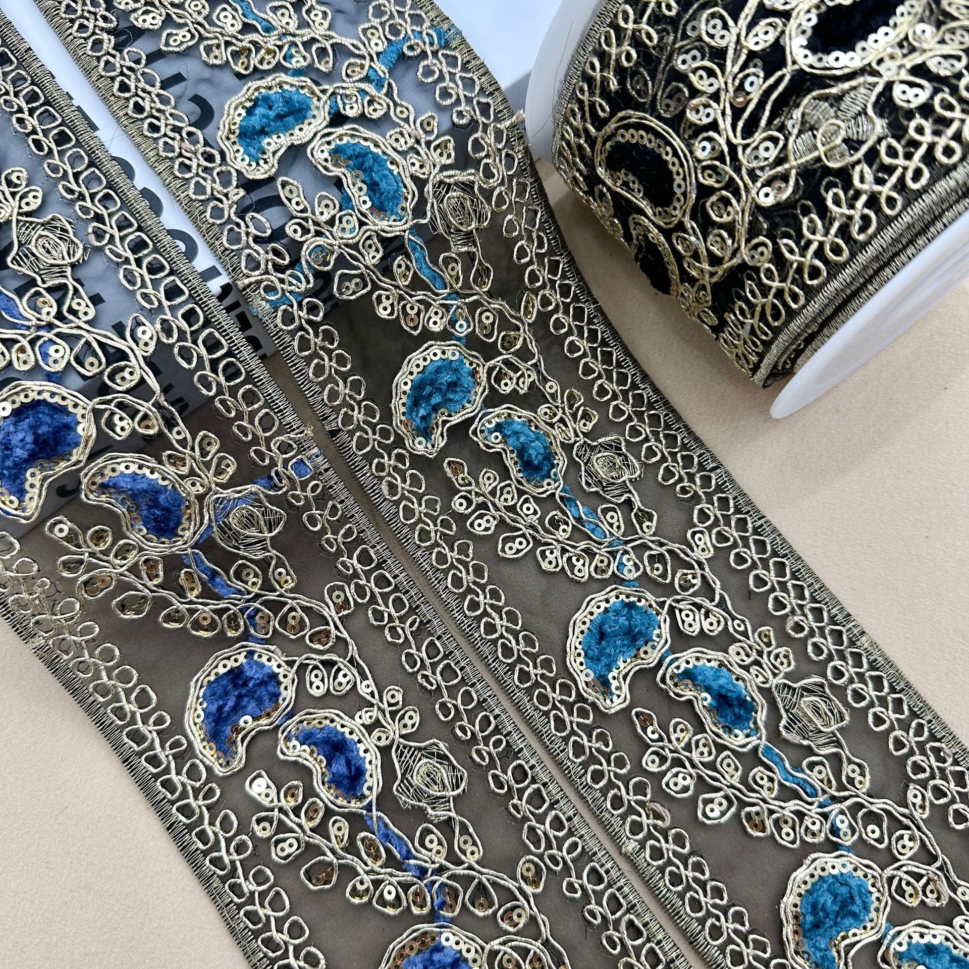 Embroidered sequin lace trim in dark base with blue floral oval details