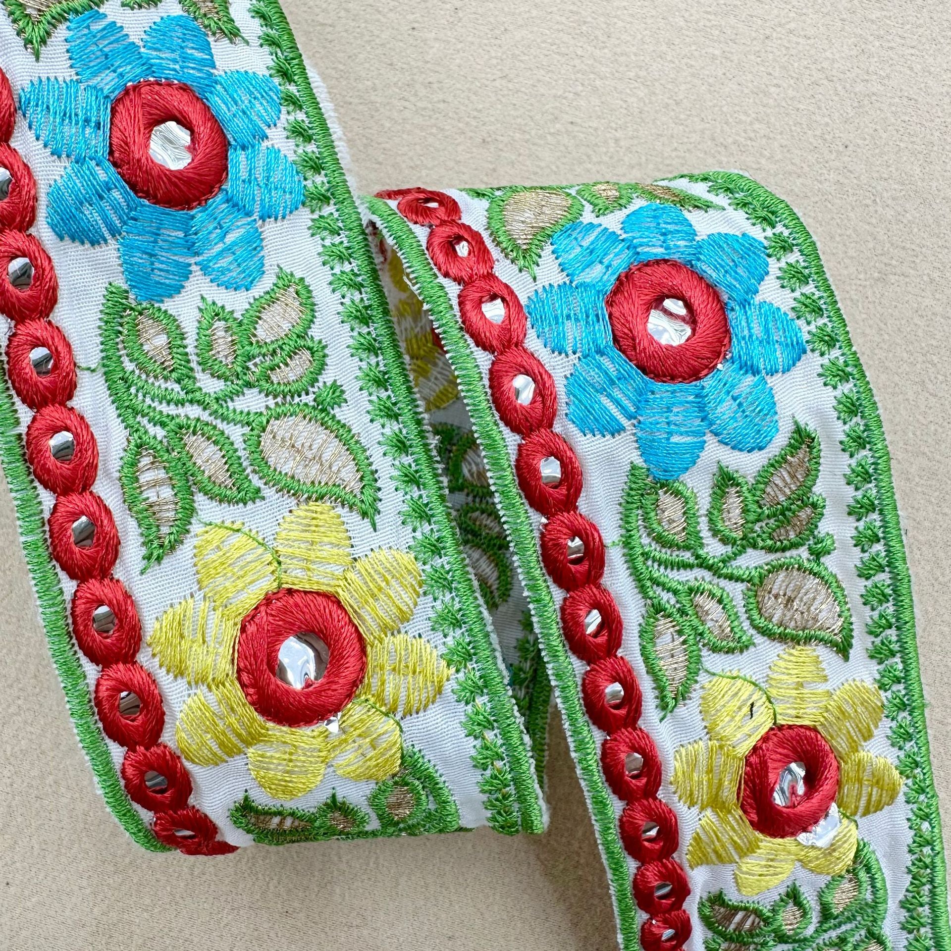 Sunflower lens lace trim, green-edged white base with blue flowers, yellow blooms, red eyelet trim