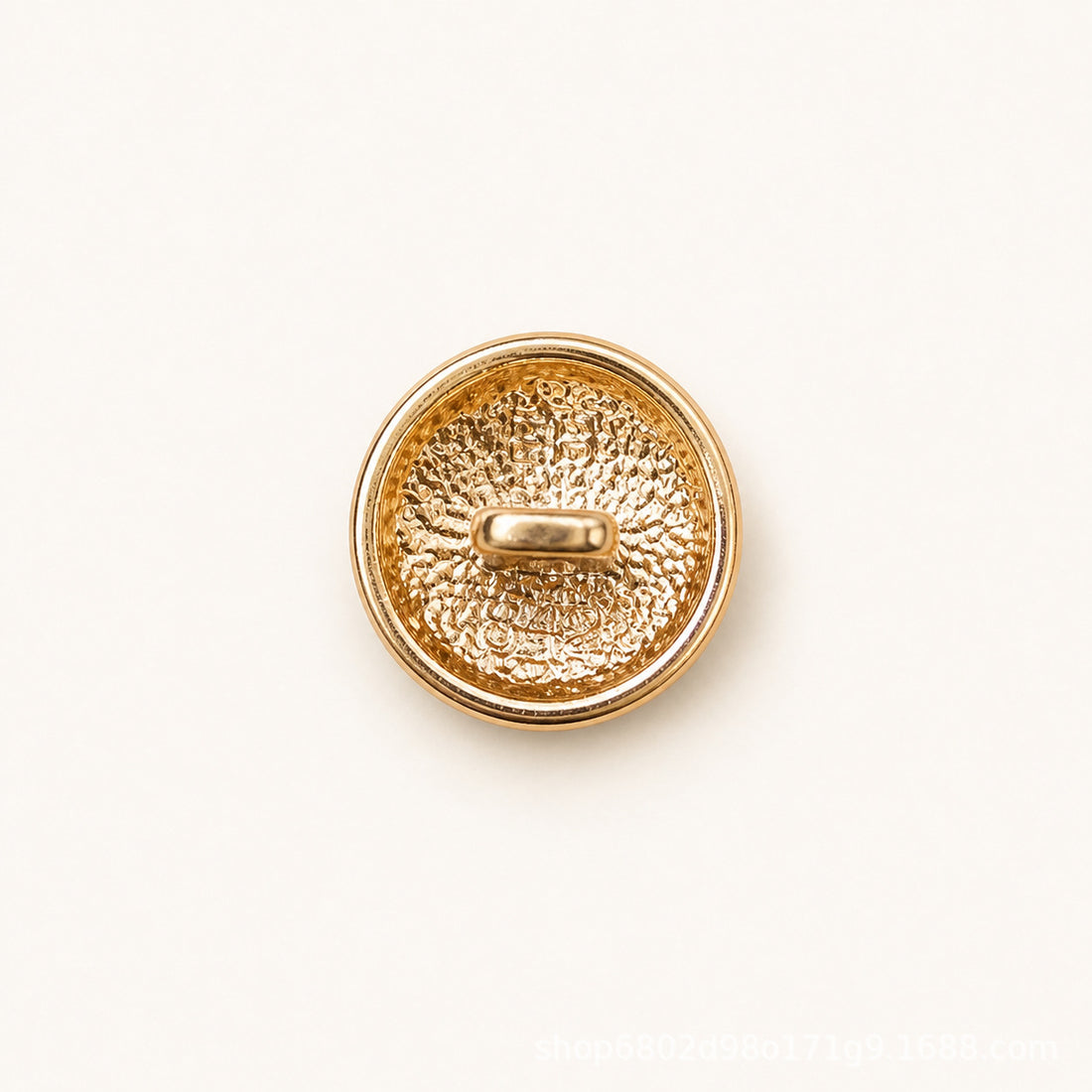 Round metal shank button with white embossed face and gold double-ring stripe