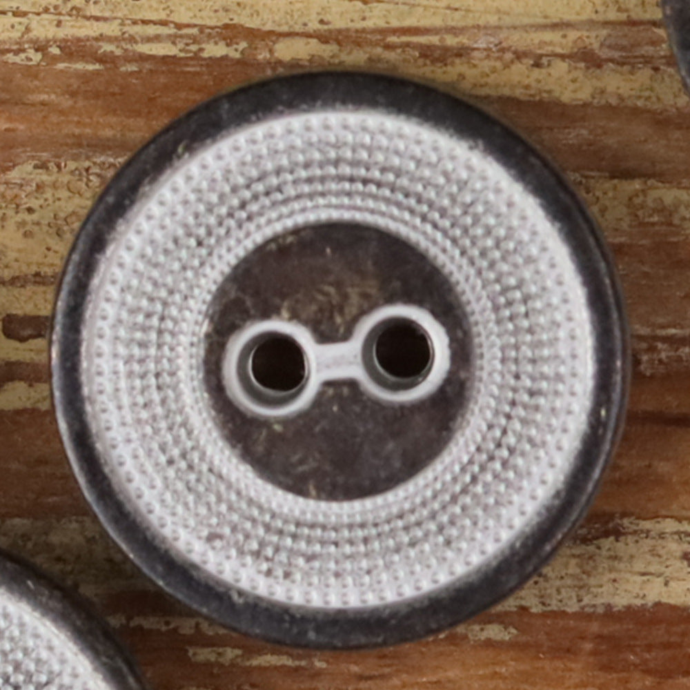 Close-up of a 2-hole metal button with concentric circle texture, silver finish