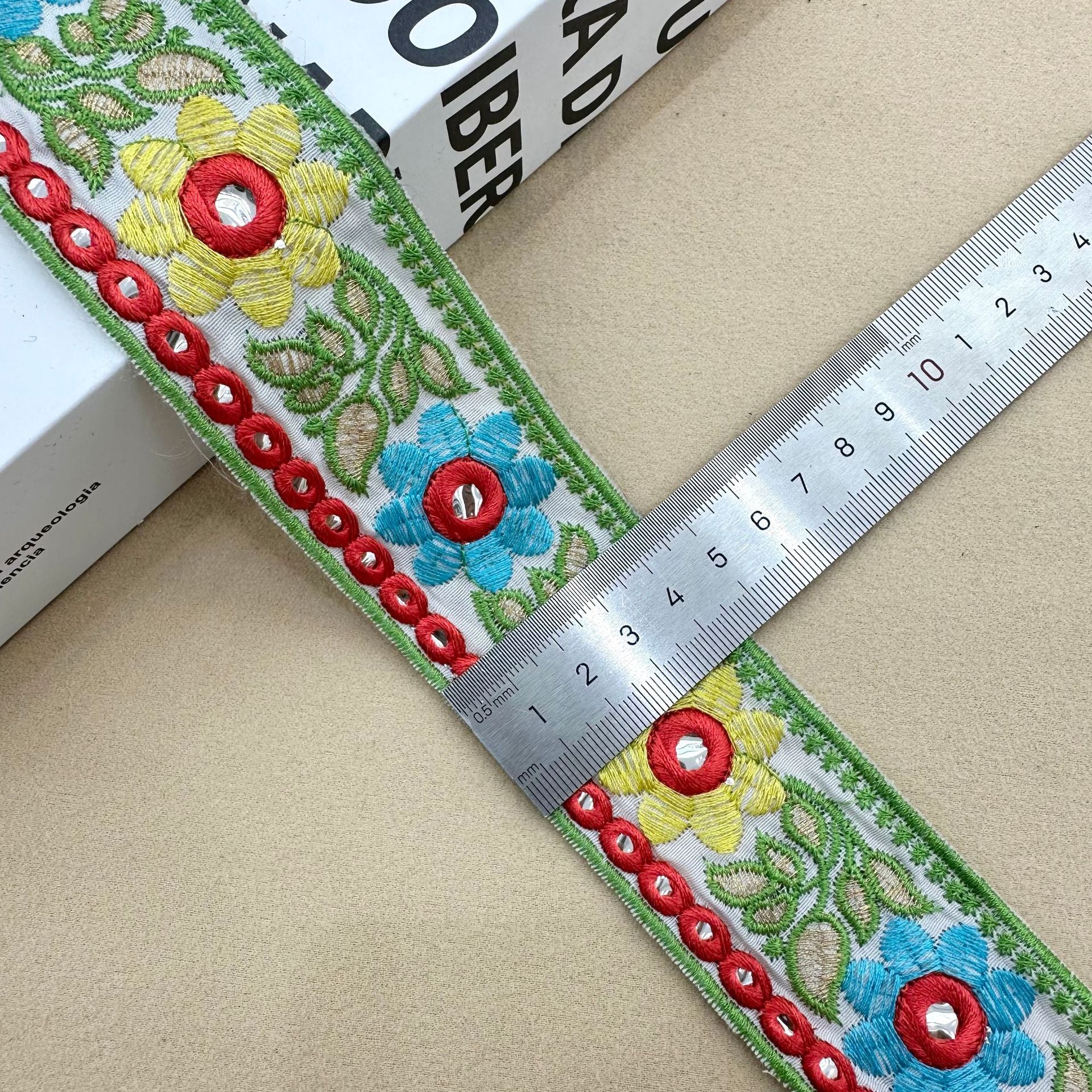 Sunflower lens lace trim on light base, green edging, blue/yellow flowers, red eyelets