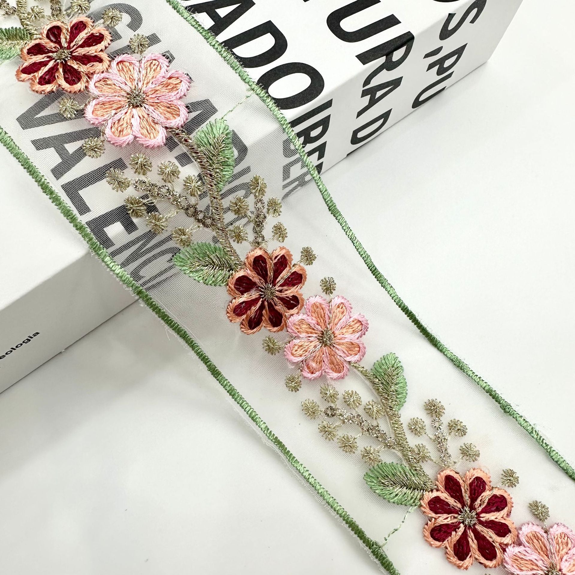 Red and blush organza lace trim with layered floral motifs, gold sprigs and green edging