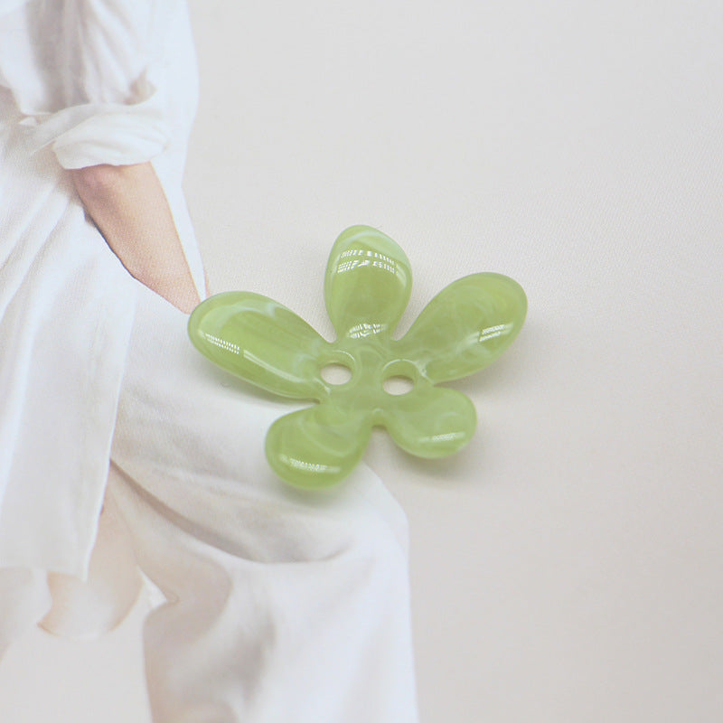 Green ombré 5-petal resin flower sewing button, two-hole design, glossy finish.