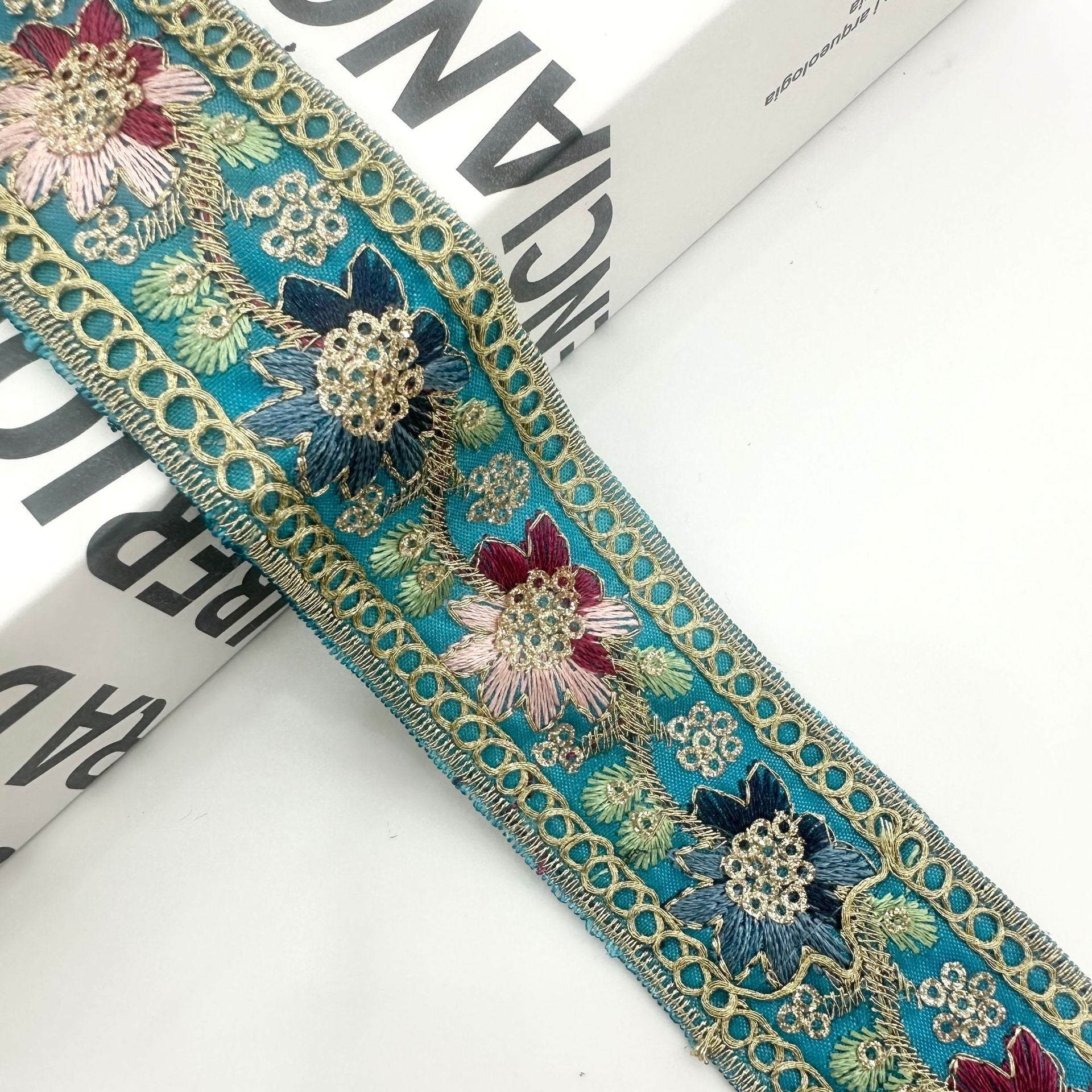 Teal embroidered ribbon trim with gold chain edge and multicolor floral sequin motifs