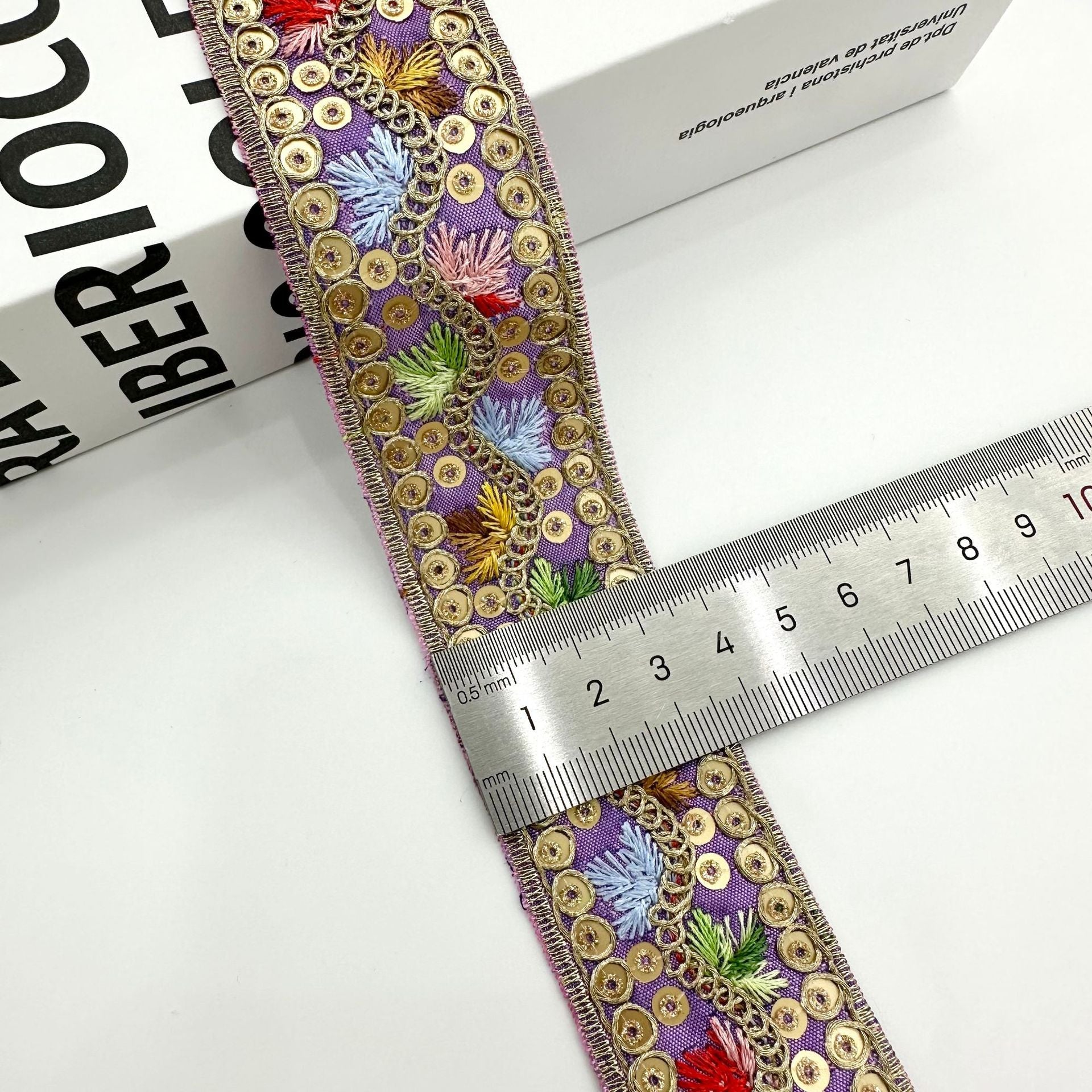 3,5 cm Jacquard-Zierband, lila mit goldenen runden Verzierungen und bunten Stickblüten