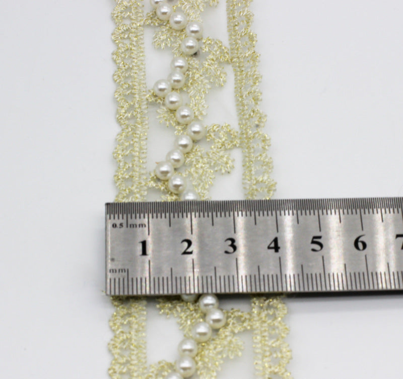 Nahaufnahme: goldene Organza-Spitze mit weißen Perlenkette, Bandbreite ca. 4–5 cm