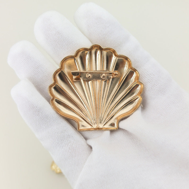 Gold scallop shell brooch, safety-pin back and clasp detail