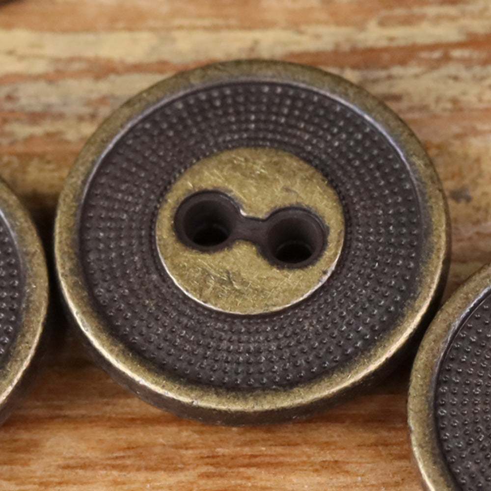 Close-up of a 2-hole metal button with concentric circle edge texture, silver finish