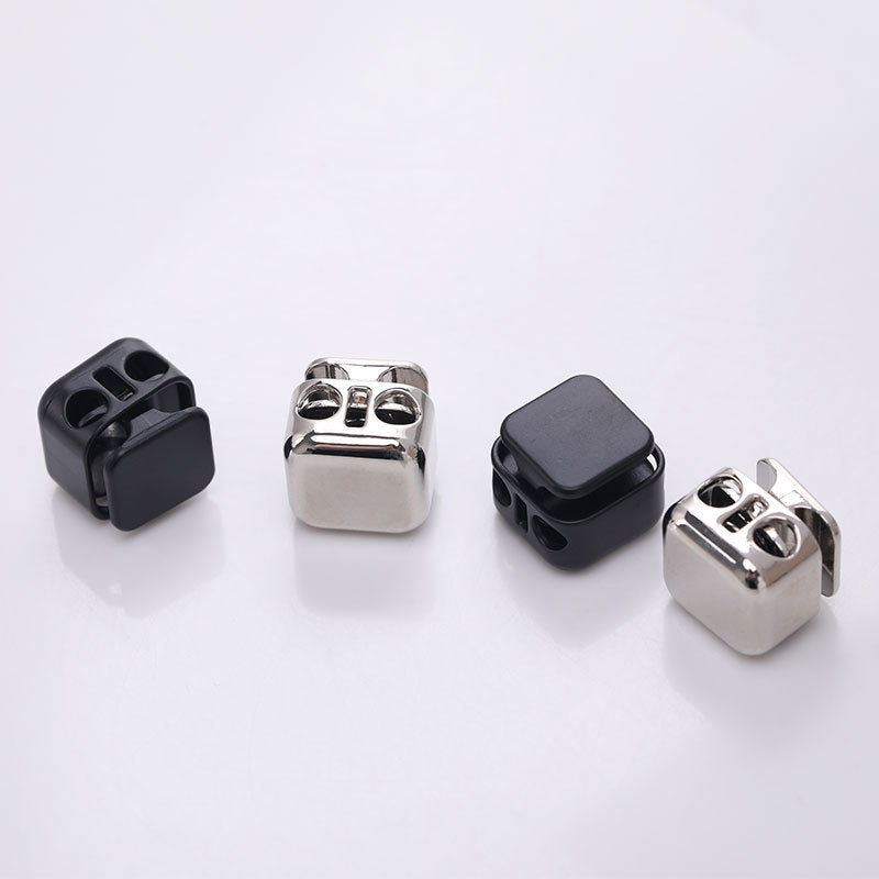 Square two-hole metal spring cord locks, black and silver, angled views