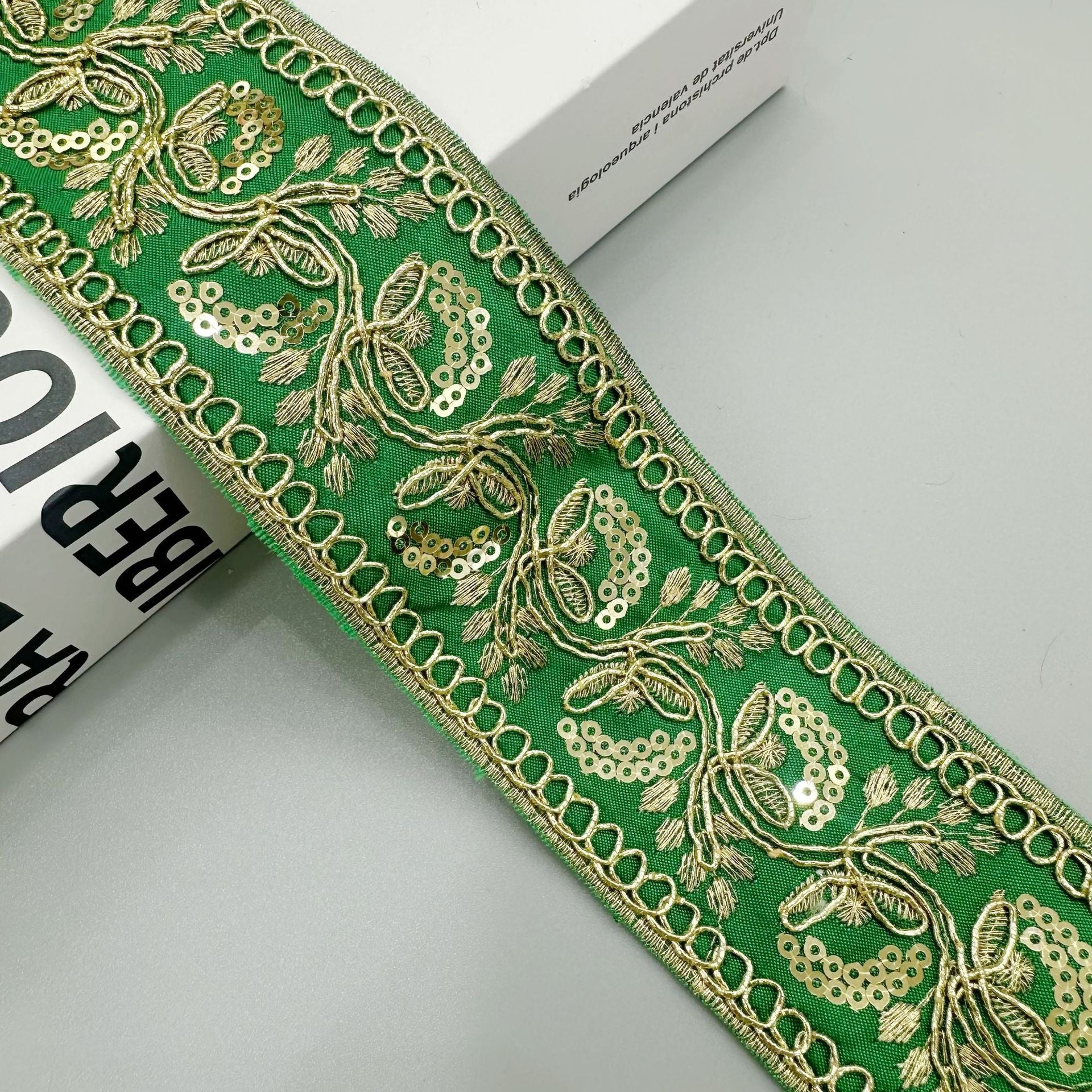 Gold sequin embroidered lace trim ribbon in green with floral scroll and chain border