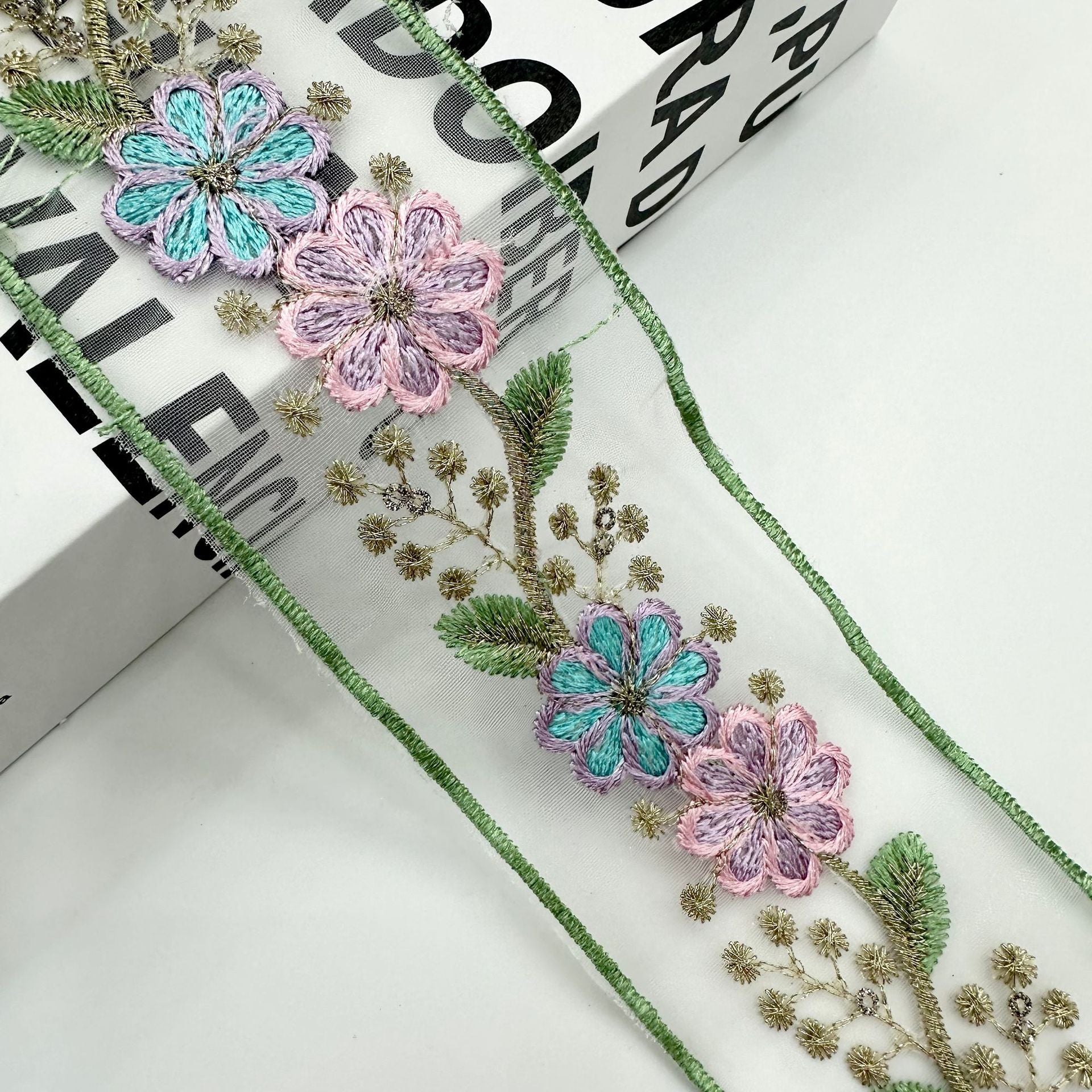 Pastel organza lace trim with turquoise and pink flower embroidery, gold sprigs and green border