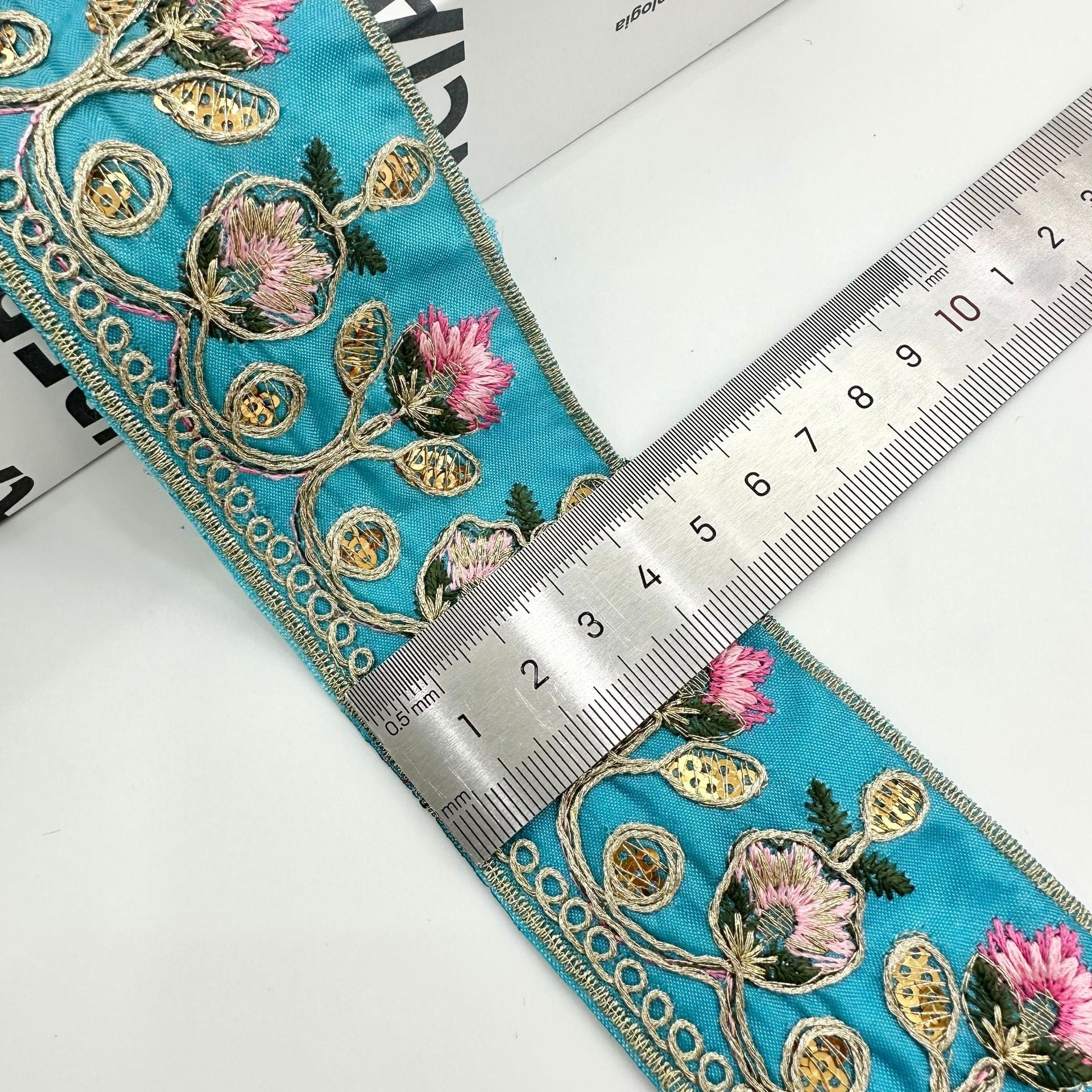 Teal embroidered lace trim ribbon with gold round accents and pink floral elements