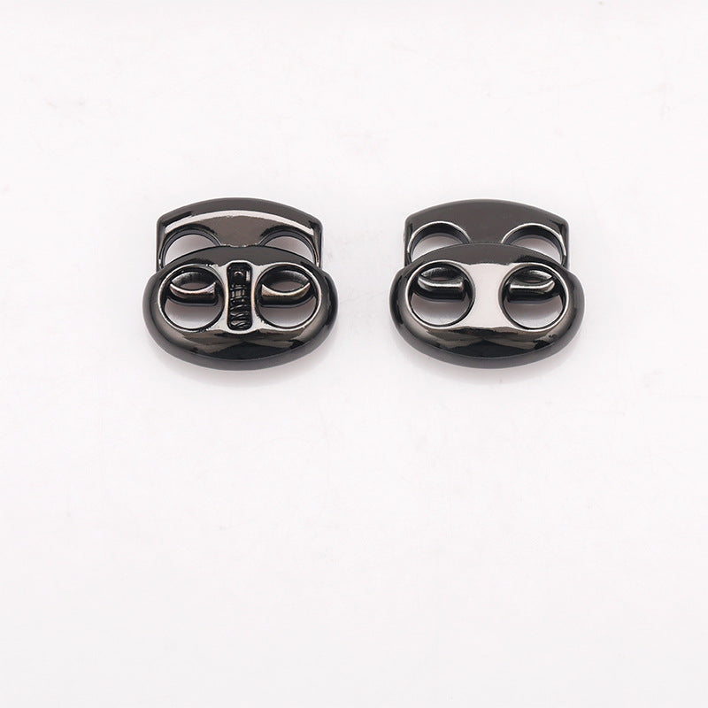 Two oval pig nose two-hole metal cord locks in gunmetal and black finishes