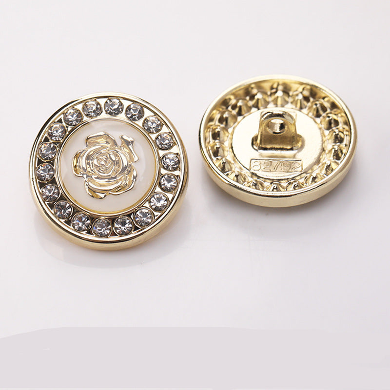 Runder Zierknopf mit goldfarbener Umrandung, Strasskranz und Blumenmotiv im Zentrum