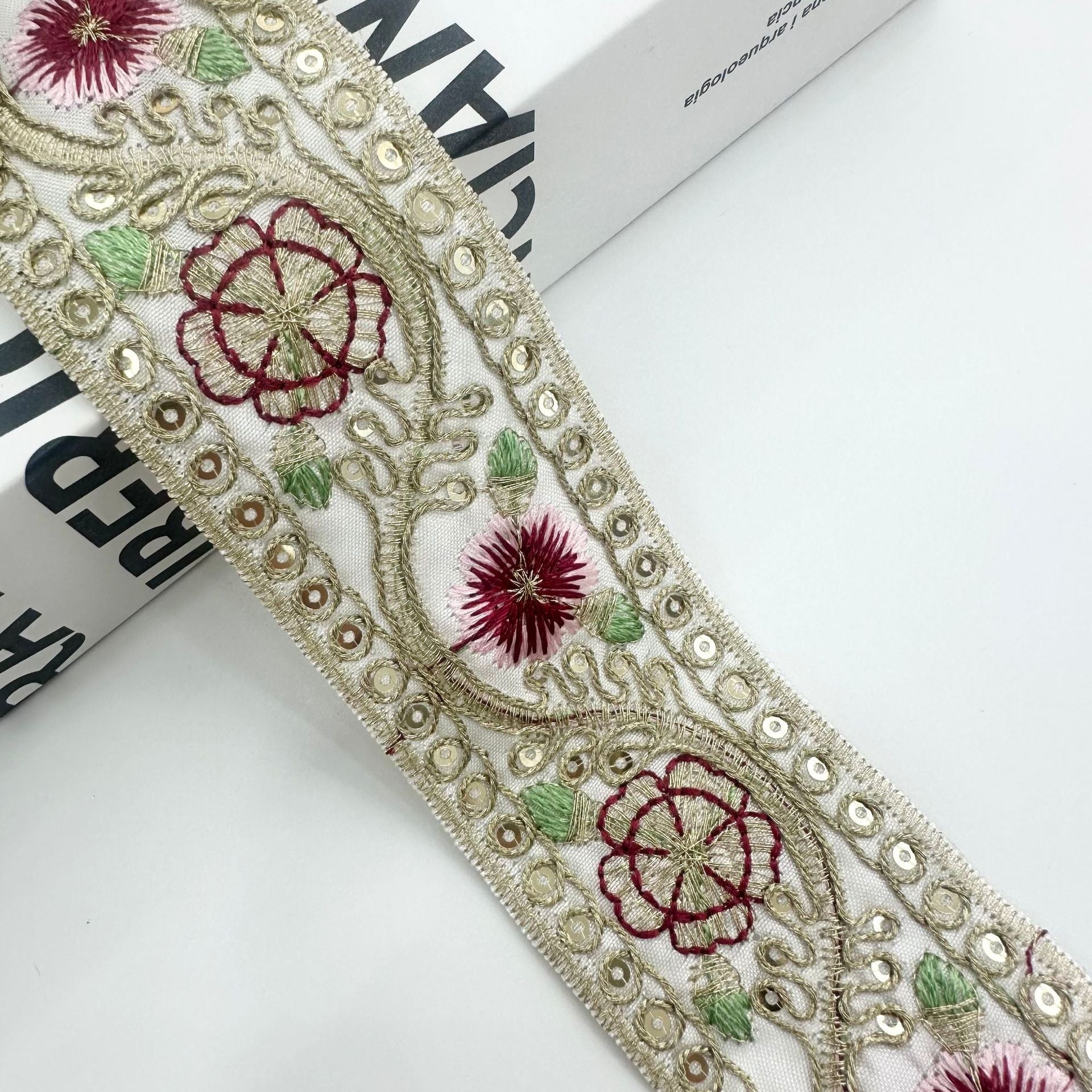 Beiger bestickter Besatz mit roten Blüten, roter Rankenstickerei, grünen Blättern