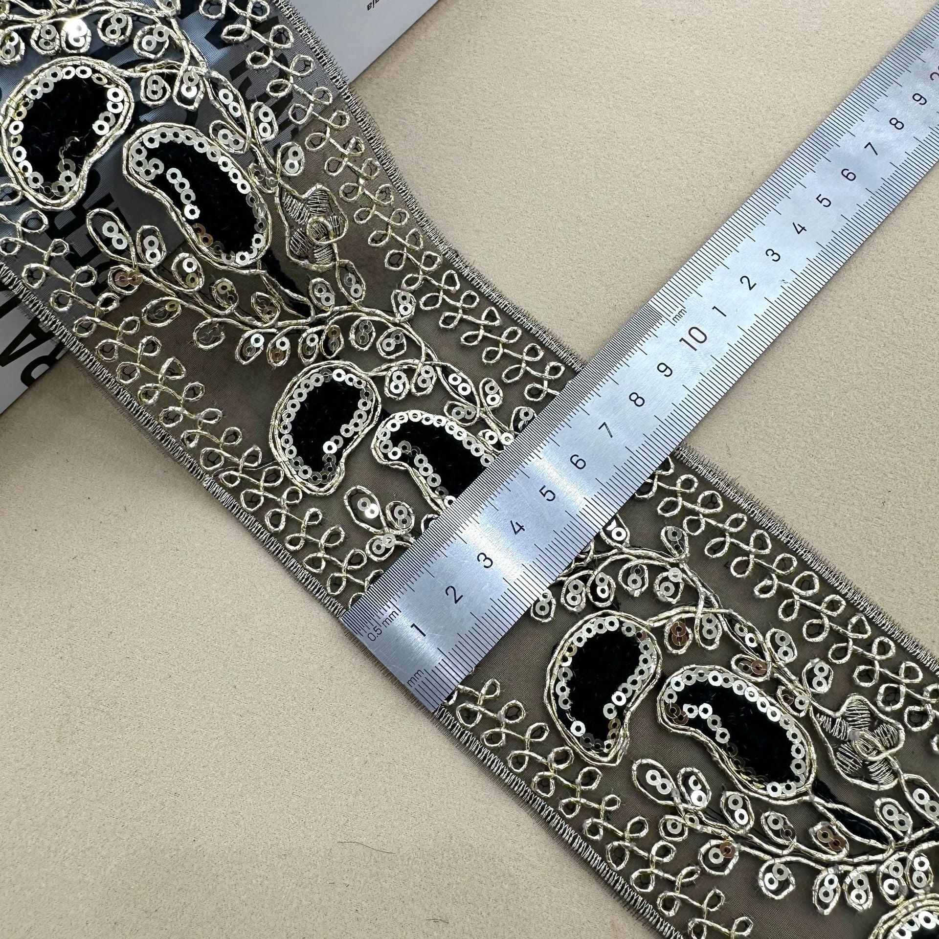 Dark lace trim with silver sequins and blue teardrop/oval motifs, 8 cm