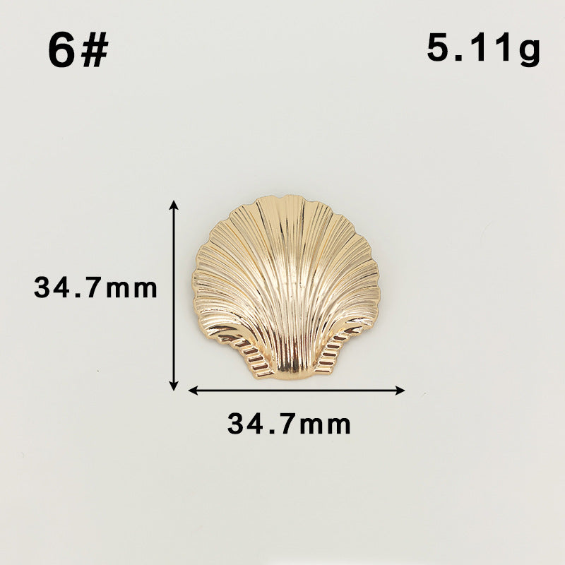 Gold scallop shell brooch with safety-pin clasp, ribbed fan shape