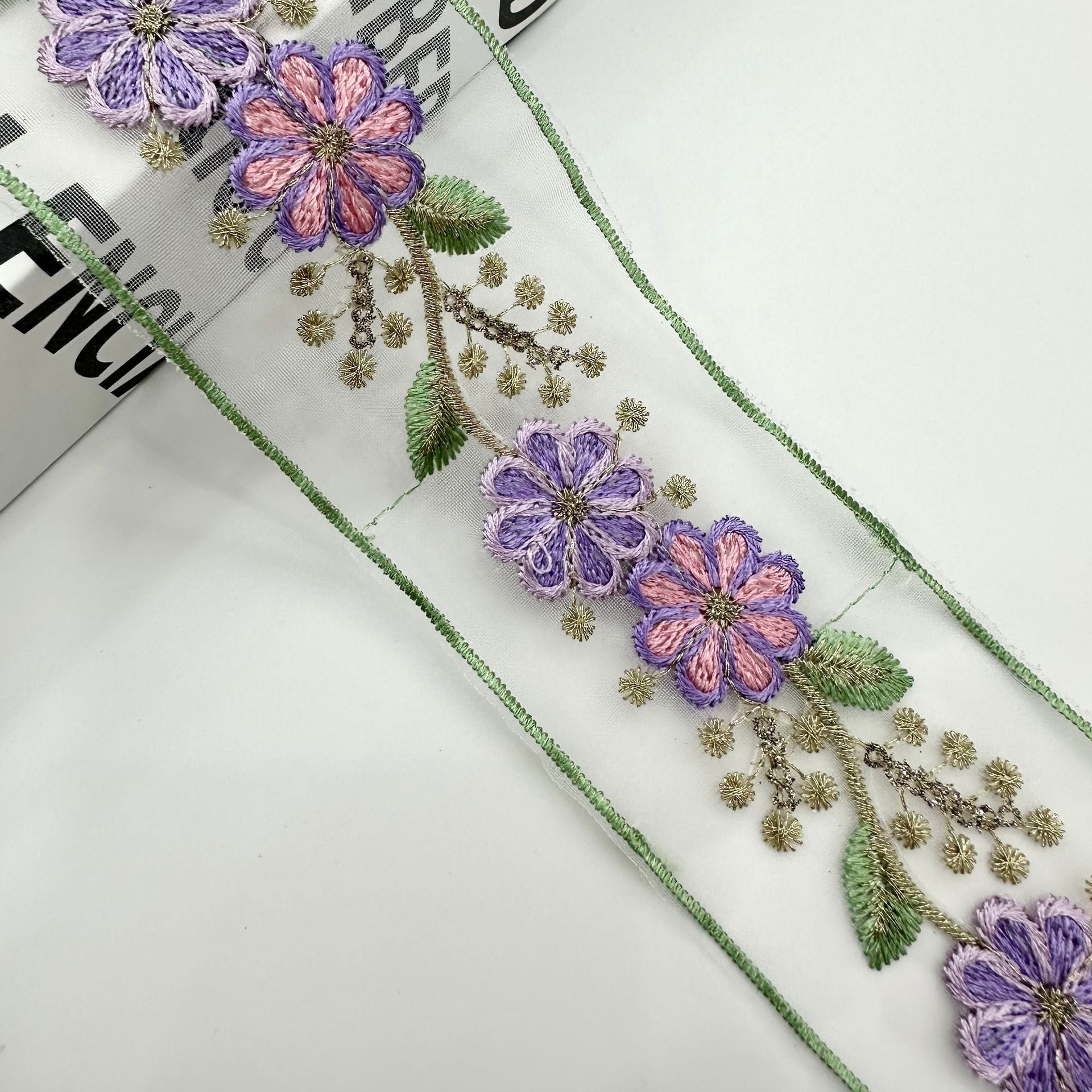 Lavender and mauve organza lace trim with floral embroidery, gold leaves and green piping