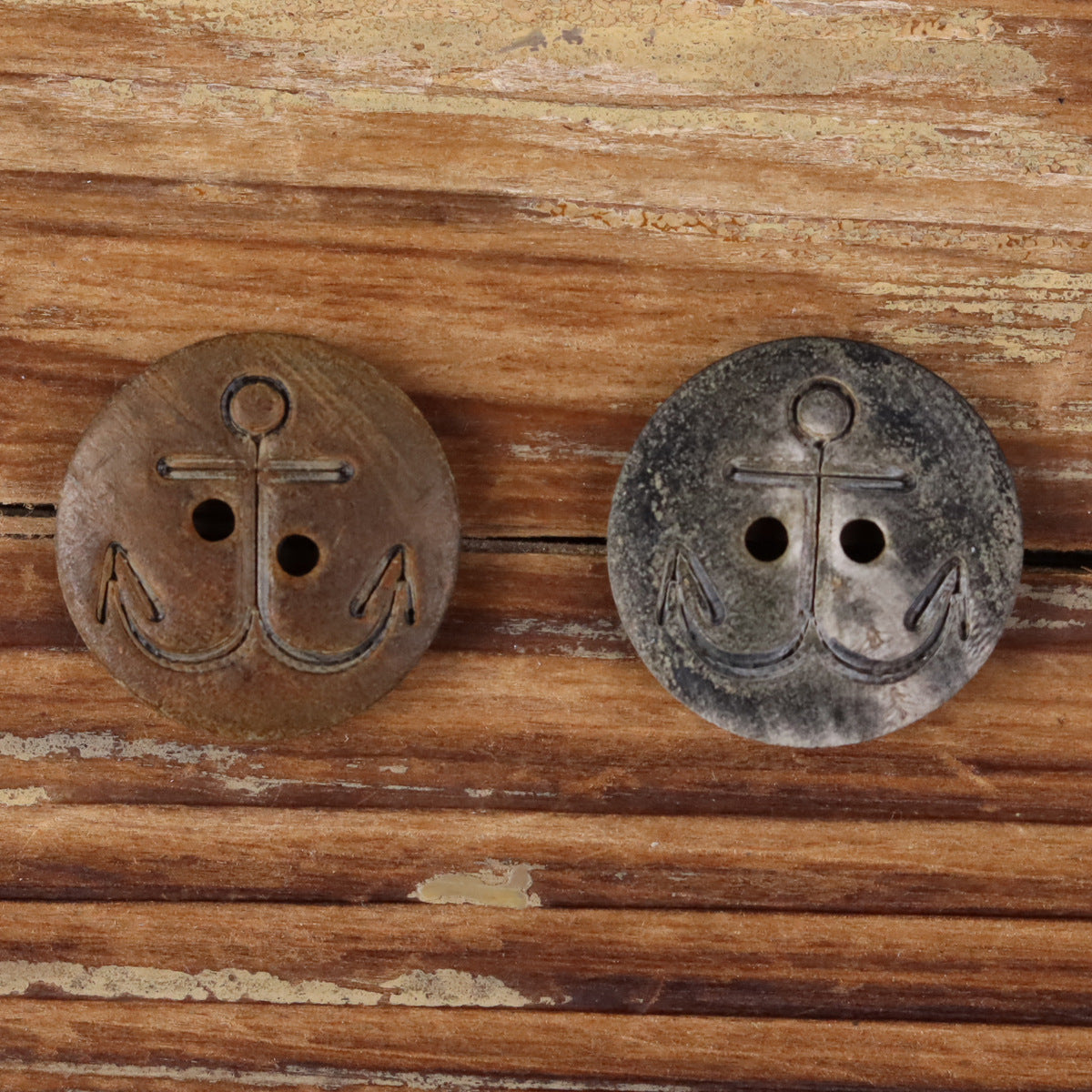 Two anchor buffalo horn buttons, one brown and one dark gray, each with four holes