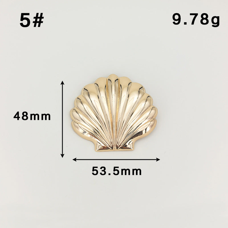 Gold scallop shell brooch with safety-pin clasp, fan ridges