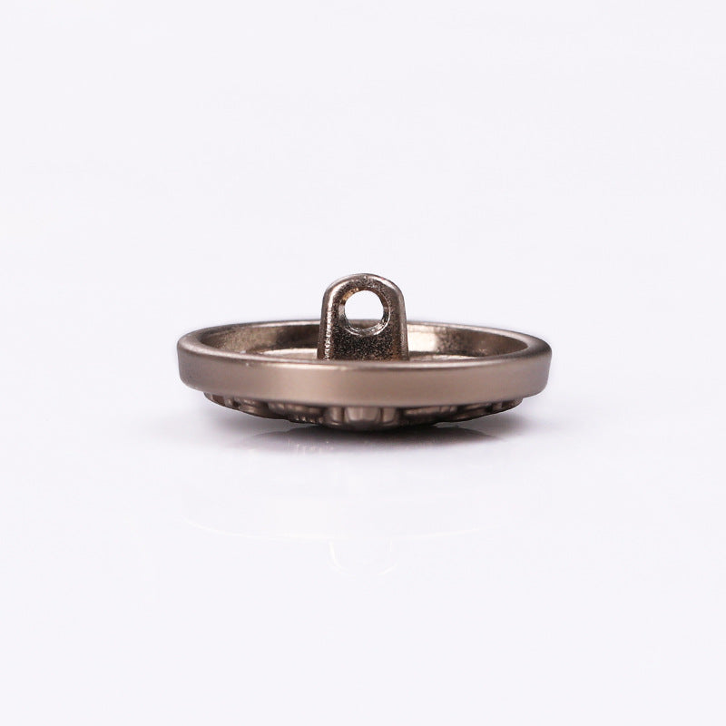 Tea-tone round metal shank button from side, small loop shank visible