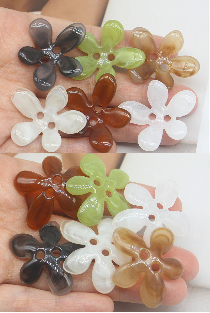Mixed-color 5-petal resin ombré sewing buttons, two-hole flower design in hand.