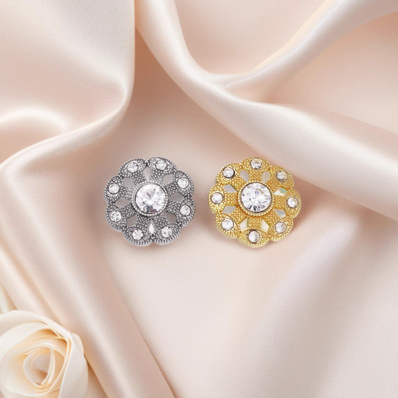 Two rhinestone shank buttons on fabric: silver-tone and gold-tone, each with round center crystal