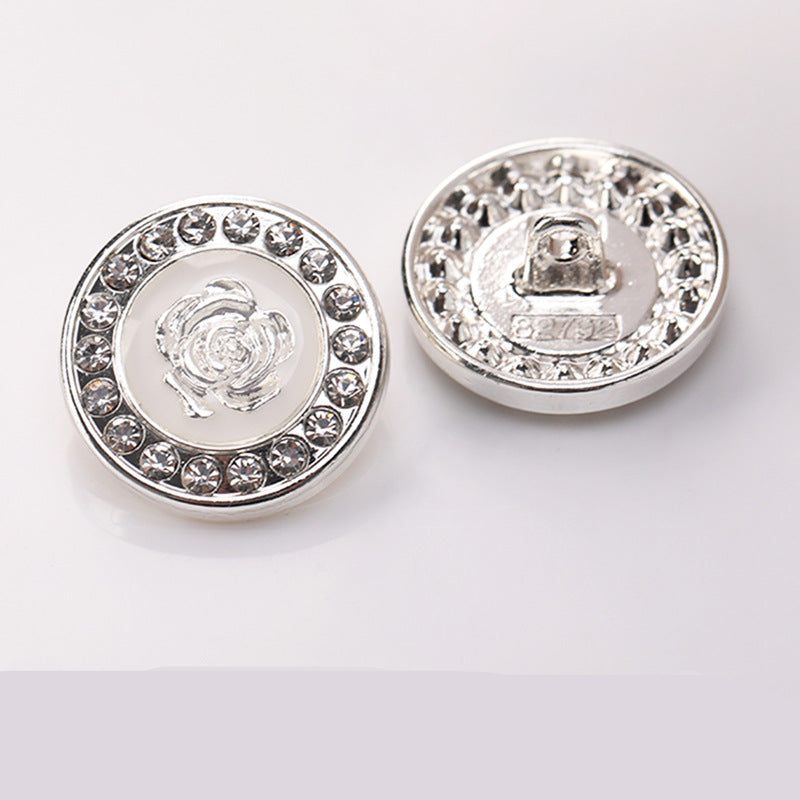 Runder Zierknopf mit silberfarbener Umrandung, Strasskranz und Blumenmotiv im Zentrum