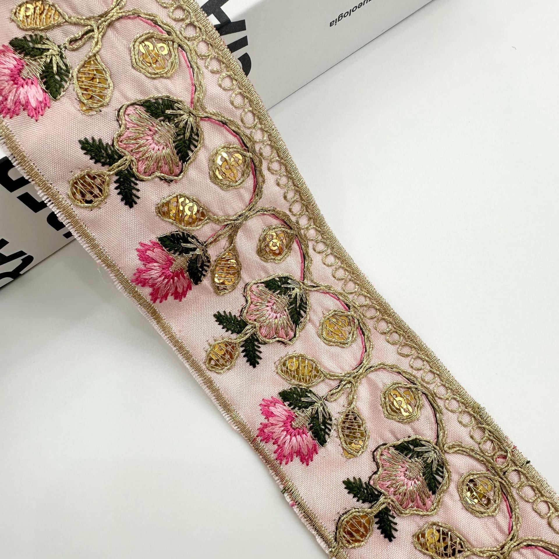 Light pink embroidered lace trim ribbon with pink flowers, gold bead details, and vines