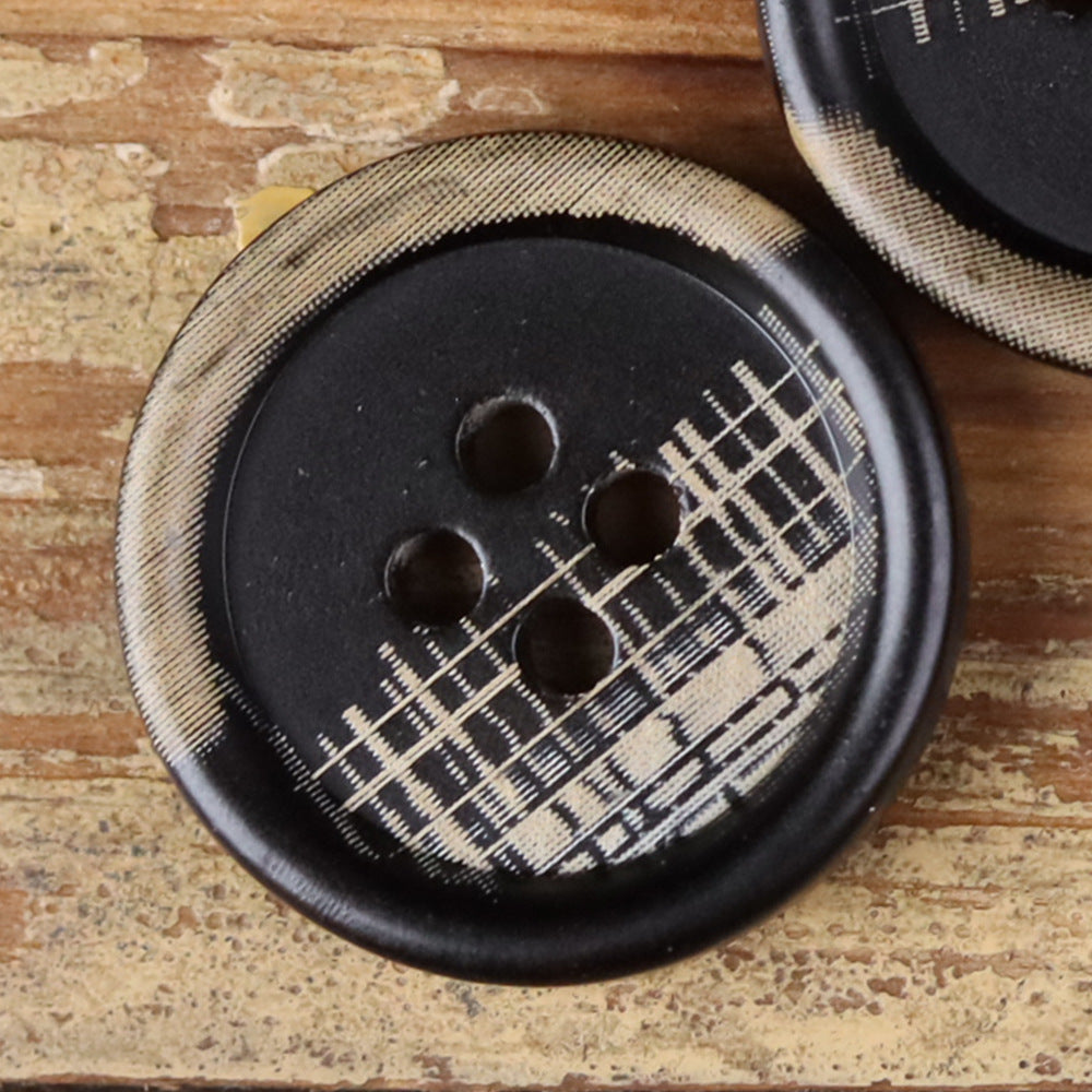 Close-up of a 4-hole round horn-style button with four holes on a dark face