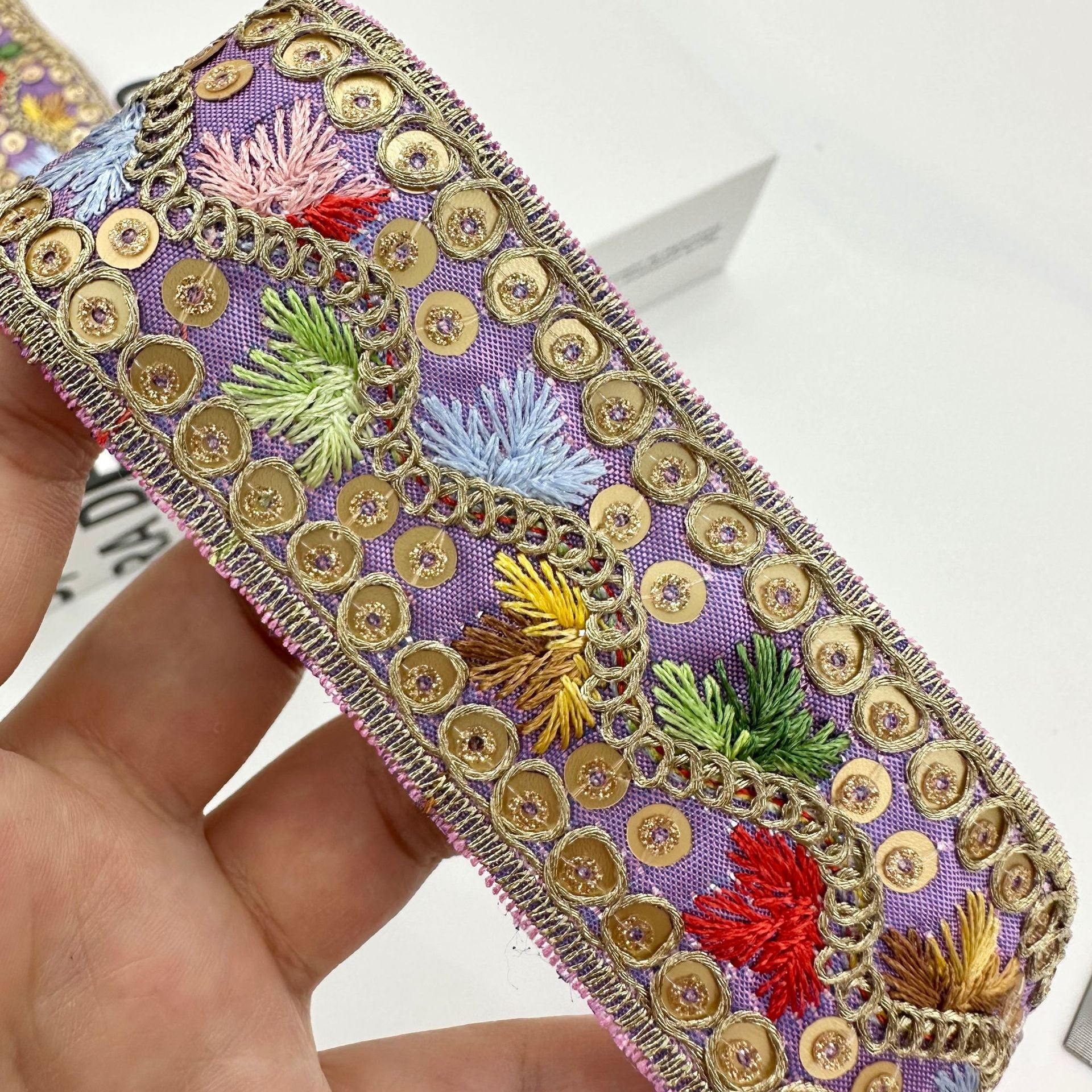 Jacquard-Zierband 3,5 cm, lila mit goldenen Osenverzierungen und bunten Blütenstickereien