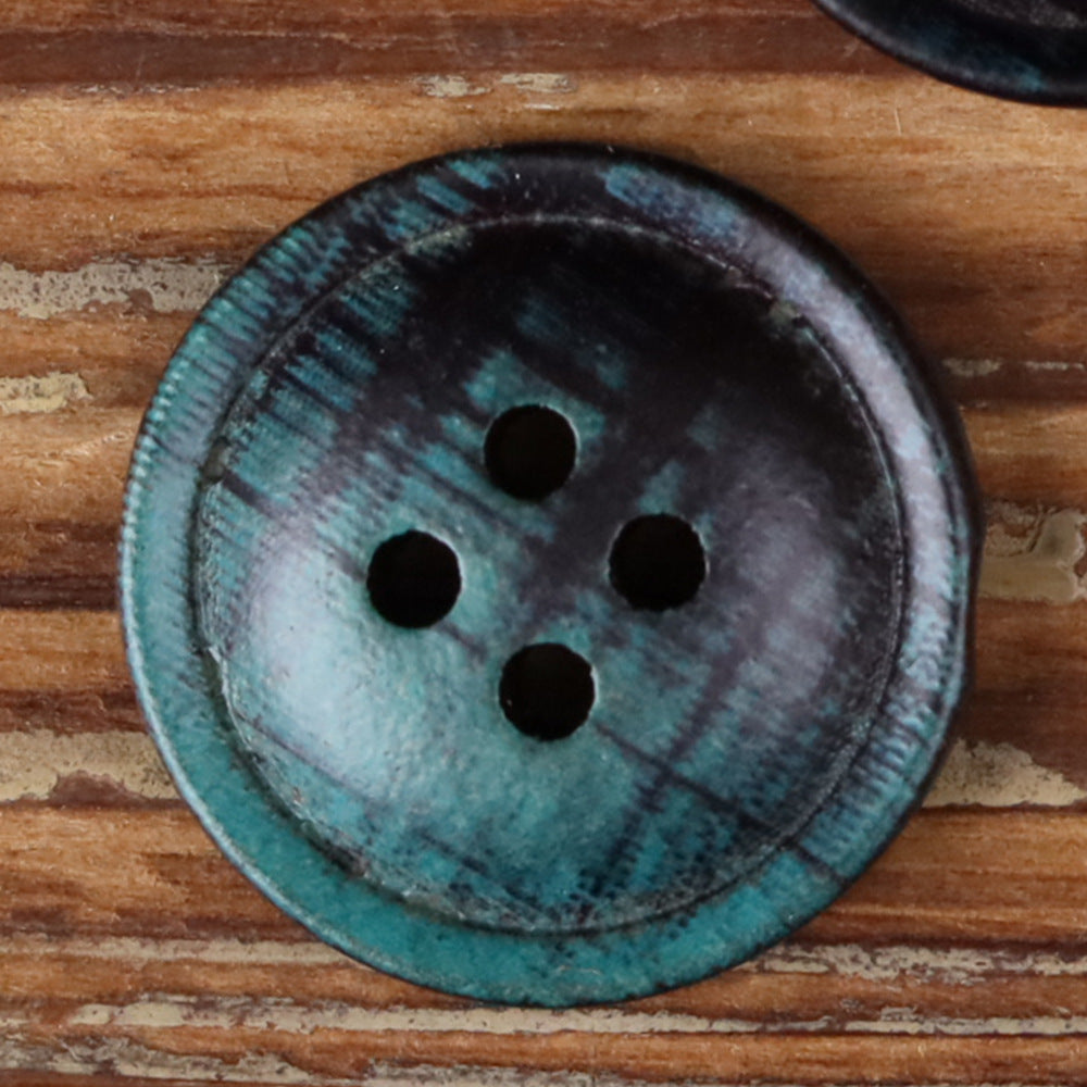4-hole round button close-up, blue plaid fabric with four black holes