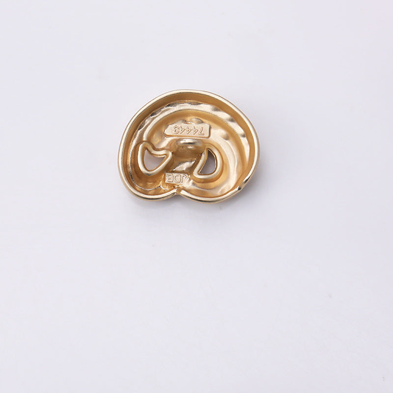 Gold ear-shaped metal shank button, back side with central rivet