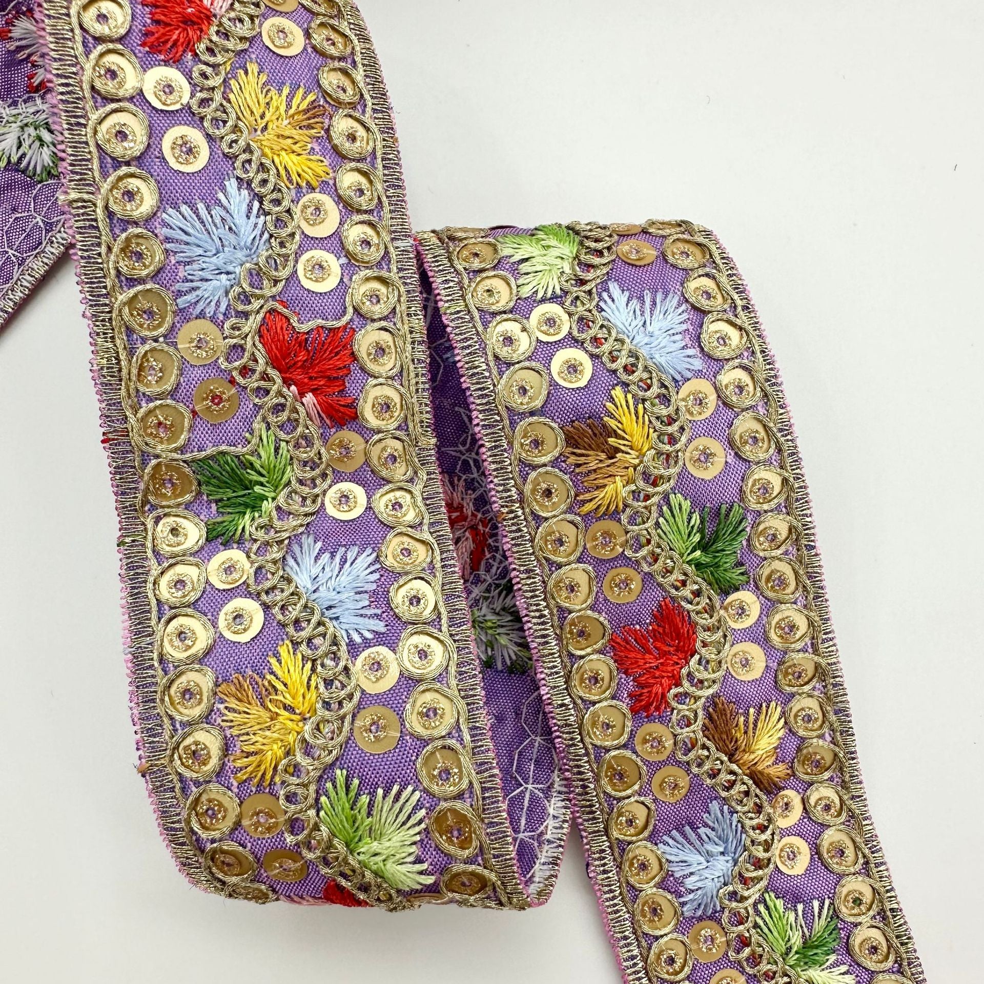 Jacquard-Zierband, lila mit goldenen Paillettenringen und mehrfarbigen Blütenstickereien