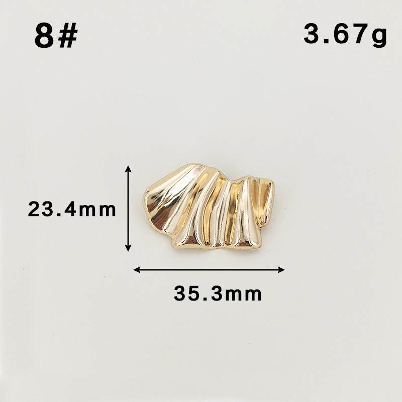 Broche dorado ondulado con textura acanalada y pasador de seguridad