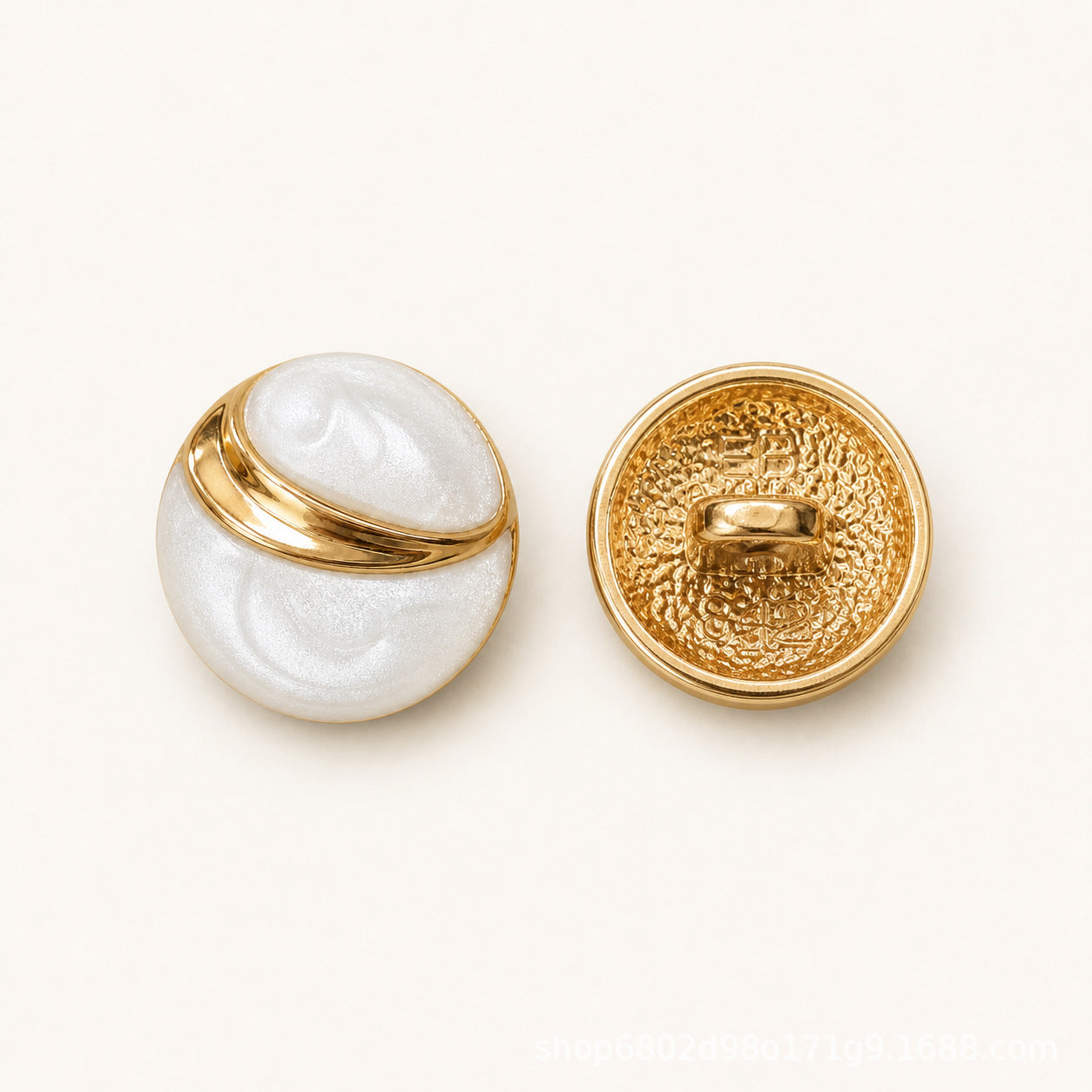 Pair of round buttons: white embossed front and textured gold back with oval shank