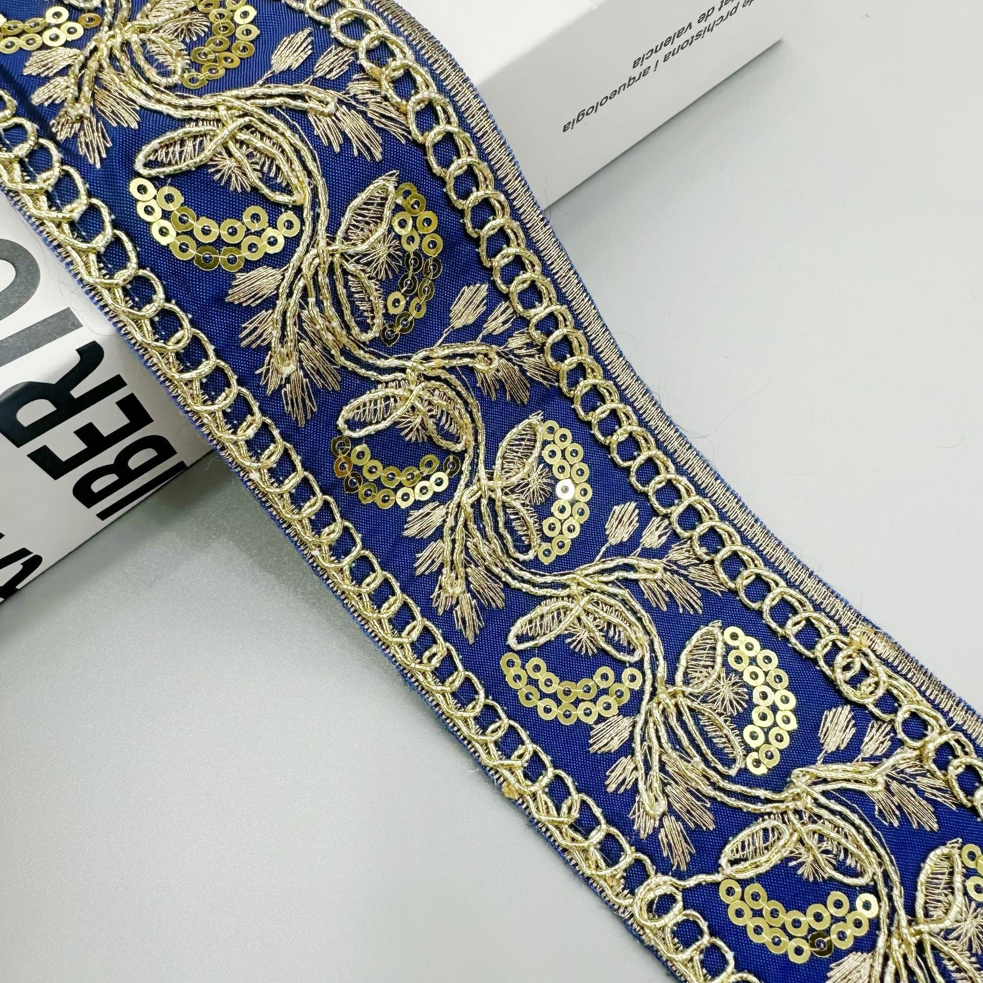 Gold sequin embroidered lace trim ribbon in royal blue with ornate floral and chain trim